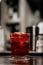 Vertical shot of a glass of Negroni on the bar with a blurry background