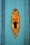 Vertical shot of a golden keyhole on a turquoise wooden background