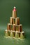 Vertical shot of golden paper cups ordered in pyramid form with Santa clause hat on top