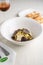 Vertical shot of a gourmet truffle pasta dish near a plate of bread at a restaurant