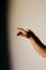 Vertical shot of a graceful hand with a shadow on a white background