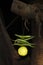 Vertical shot of green anaheim peppers and lemon hanging on a string from a tree branch