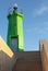 Vertical shot of a green lighthouse at daytime