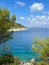 Vertical shot of the green shoreline and blue sea.