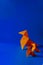 Vertical shot of a group of orange origami figures on blue background