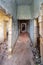 Vertical shot of a group of tourists walking in along a hallway inside a destroyed historic building