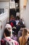 Vertical shot of a group of tourists walking up narrow stairs going up hill to the Fortica castle above the city of Omis in