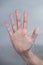 Vertical shot of a hand behind on a moist glass