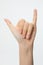 Vertical shot of a hand gesturing the shaka symbol isolated on a white background