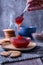 Vertical shot of a hand holding a spoon of strawberry jam