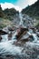 Vertical shot of hikers near a waterfall