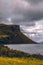 Vertical shot of the historic Isle of Skye cliff over the water under a cloudy sky in Scotland