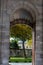 Vertical shot of a historical arch leading to a beautiful park