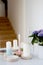 Vertical shot of a home decor of five candles a glass bottle and flowers