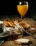 Vertical shot of honey and orange juice and a knife spreading cream on a slice of bread on a table