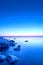 Vertical shot of an idyllic frozen rocky shore with blue and pink sunset in the background