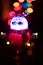 Vertical shot of an illuminated Santa Claus toy on a bokeh light background