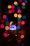 Vertical shot of an illuminated Santa Claus toy on a bokeh light background