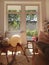 Vertical shot of the inside of a comfortable room with balls, chairs, couch, and a bookshelf