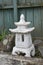 Vertical shot of a Japanese styled, white concrete lantern, in a garden