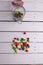 Vertical shot of a jar with colorful candies half-emptied on a wooden table