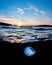 Vertical shot of a jellyfish underwater with the Sun in the horizon