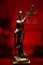 Vertical shot of lady justice bronze statue isolated on a red background