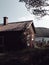 Vertical shot of a lake house in the middle of a forest under the clear sky