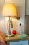 Vertical shot of a lampshade and medical mask on a bedroom shelf - new normal