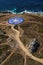 Vertical shot of a large blue compass built on the shore in front of the ocean in La Coruna, Spain