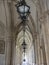 Vertical shot of a large metal lamp hanging from the ceiling of a palace