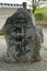 Vertical shot of large rock with Japanese symbols in a park in Ipoh, Malaysia