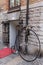 Vertical shot of a large wheel bicycle on a wall of a historical building in Gothenburg, Sweden.