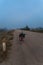 Vertical shot of a loaded touring bike standing on a dirty road in fog in the Cambodian countryside