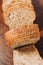 Vertical shot of a loaf of freshly sliced artisan bread, topped with edible seeds