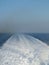 Vertical shot of a long wake in the sea made by a catamaran