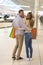 Vertical shot of a lovely Caucasian couple doing shopping in a shopping centre