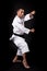 Vertical shot of a male practicing Asian martial arts on a black background