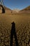 Vertical shot of a male shadow on drought cracked ground