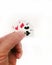 Vertical shot of a man holding a very small deck of cards behind a white background