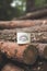 Vertical shot of a metallic cup with a [Happy camper] text written on it on trees in a forest