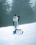 Vertical shot of a Moka pot on a portable gas stove on the ground covered in the snow outdoors