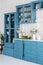 Vertical shot of monochrome kitchen counter with blue drawers