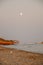 Vertical shot of the moon showing up above the coast of Menorca, Islas Baleares in Spain