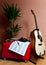 Vertical shot of musical notes next to a guitar, headphones and a plant