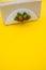 Vertical shot of a napkin holder with strawberry detail on yellow background -  copy space