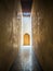 Vertical shot of a narrow corridor leading to a door in Morocco