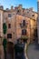 Vertical shot of a narrow paved street passing through old medieval residential buildings in Italy