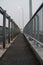 Vertical shot of a narrow sidewalk bridge lined with metal railings