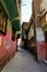 Vertical shot of a narrow street between aged buildings